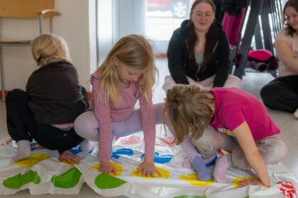 Tytöt Twister-pelin tuoksinnassa.